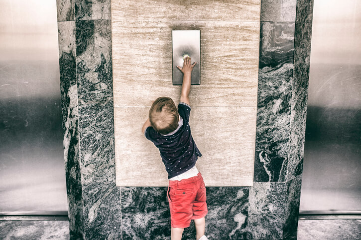 Child clicking elevator button