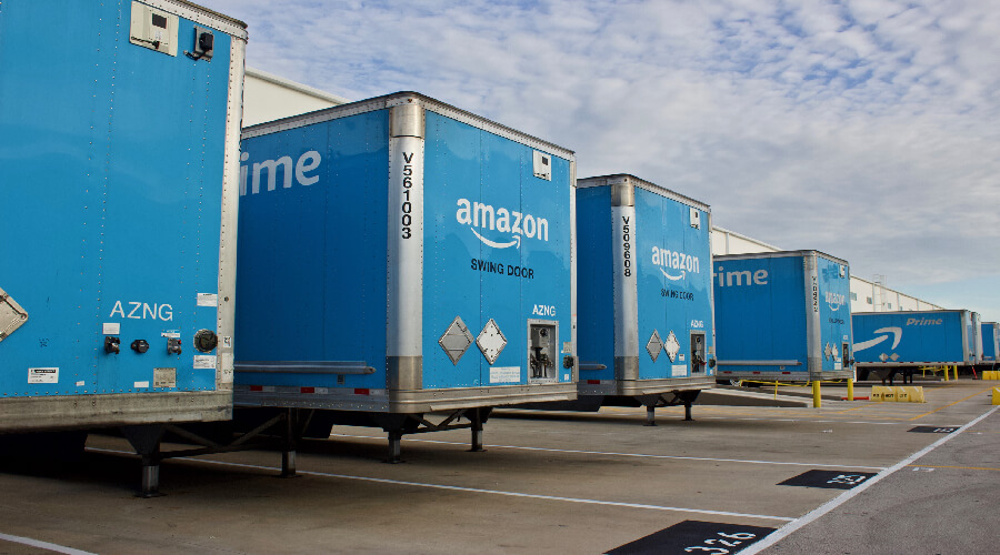 Amazon trucks parked in warehouse loading lot