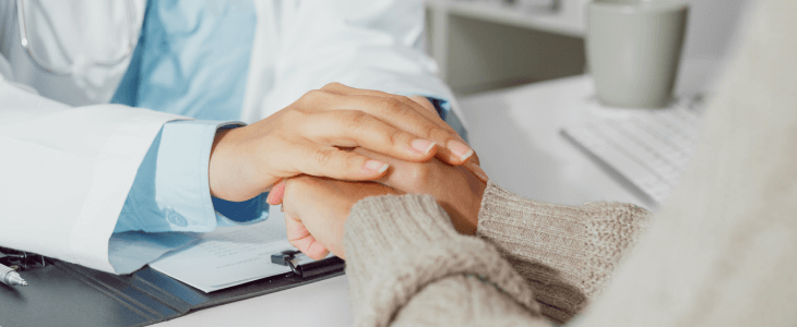 Doctor holding the hands of her patient after a misdiagnosis